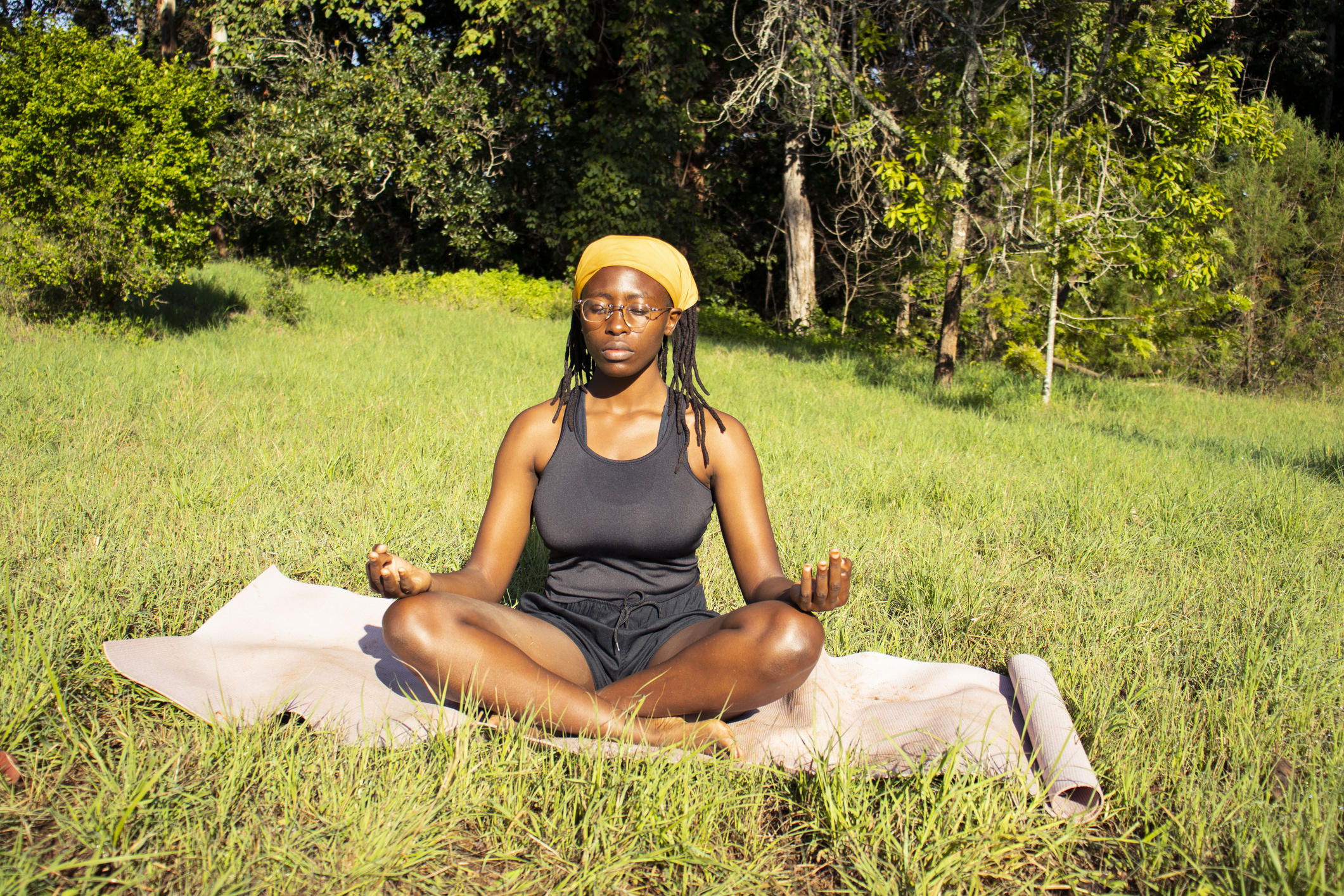 A young  black woman practicing yoga outdoors